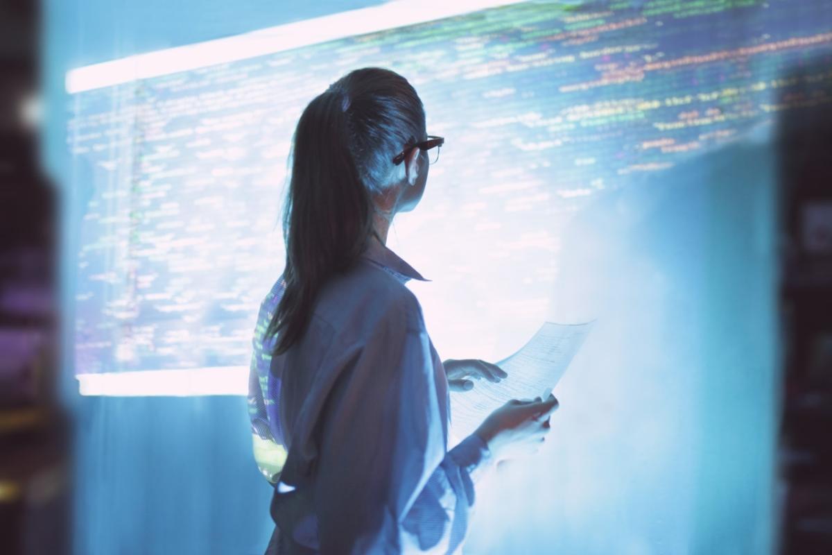 Woman looking at a wall of computer code