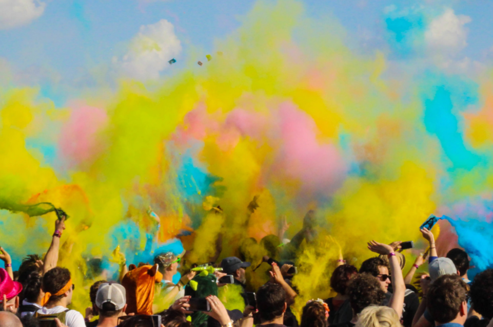 a large group of people a cloud of different colored chalk dust above them
