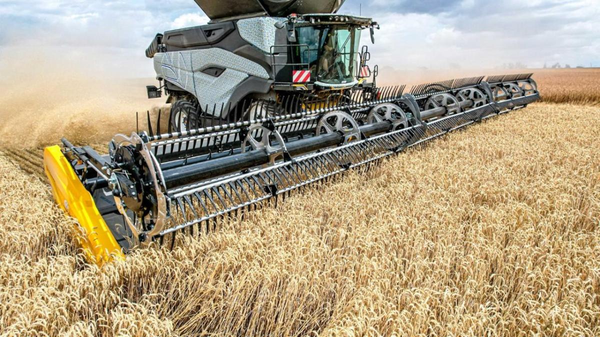 A large harvester collecting crops in a field.