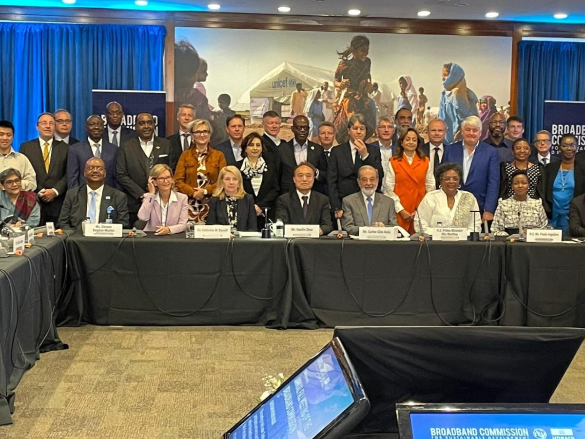 all committee members, some seated at a long table, some standing behind them.