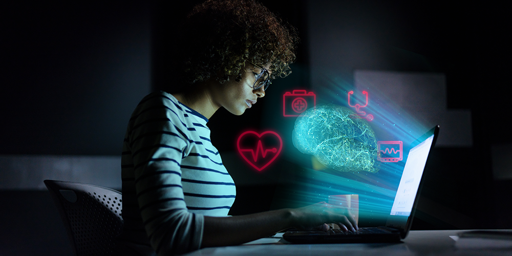 person working on laptop in the dark with artistic computer symbols shining from it