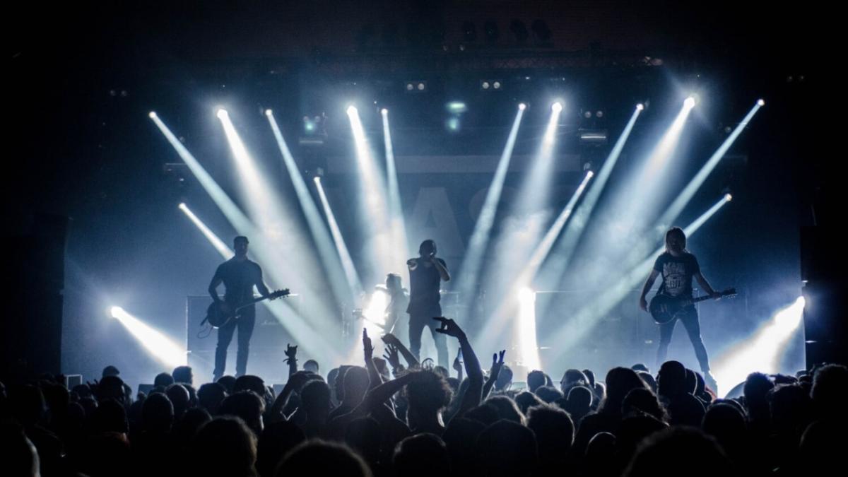 back lit concert with standing crowd in front of the stage