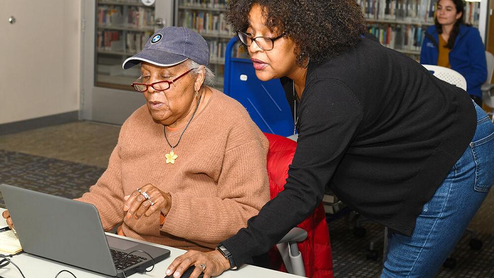 One person teaching another computer skills