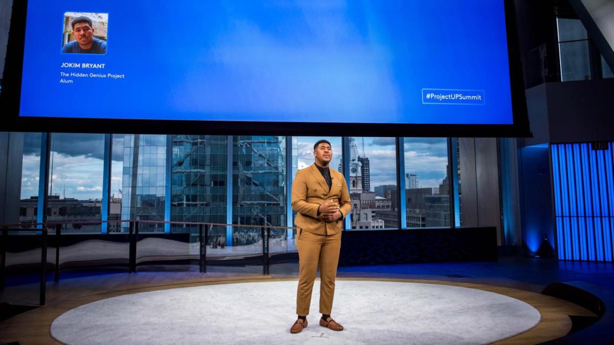 Man talking in front of screen