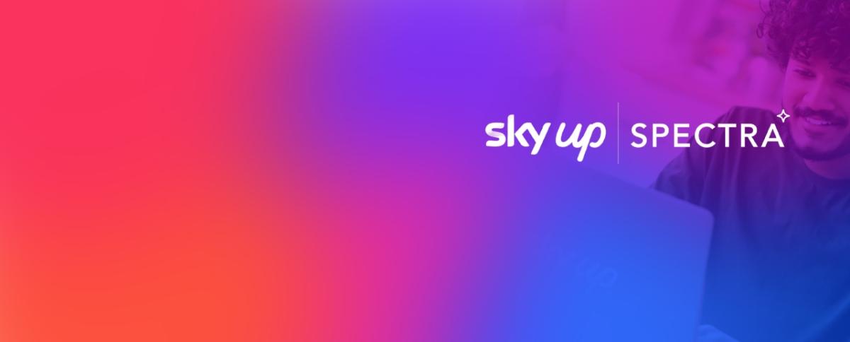 Photo of person on a laptop with colorful overlay and text: sky up, Spectra