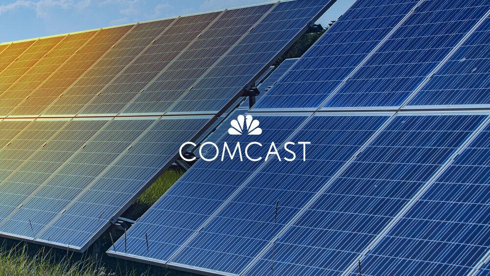Comcast logo in front of solar panels 