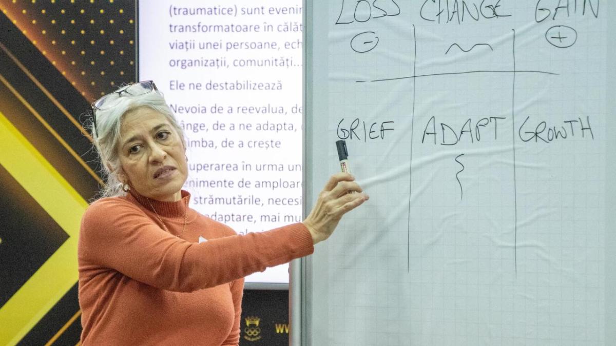 A person pointing to "grief" written on a board.
