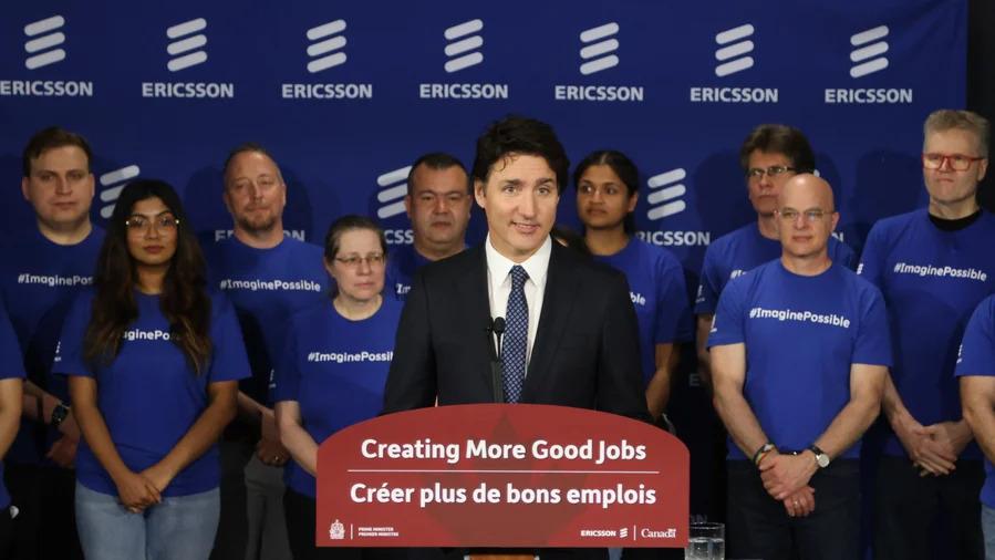 Canadian Prime Minister Justin Trudeau speaking at a podium, a small group of people behind him.