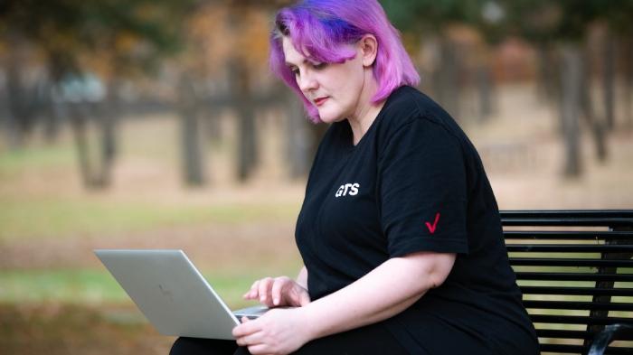 Crystal Morris sitting on a park bench with a computer