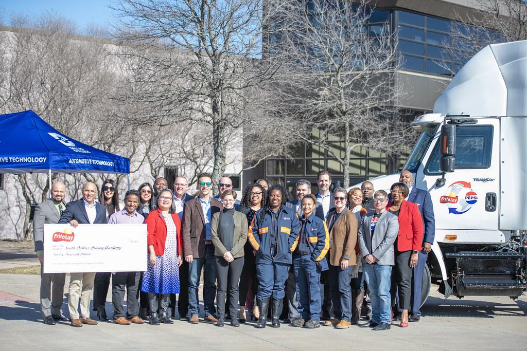 A group of people posed outside in front of a semi truck