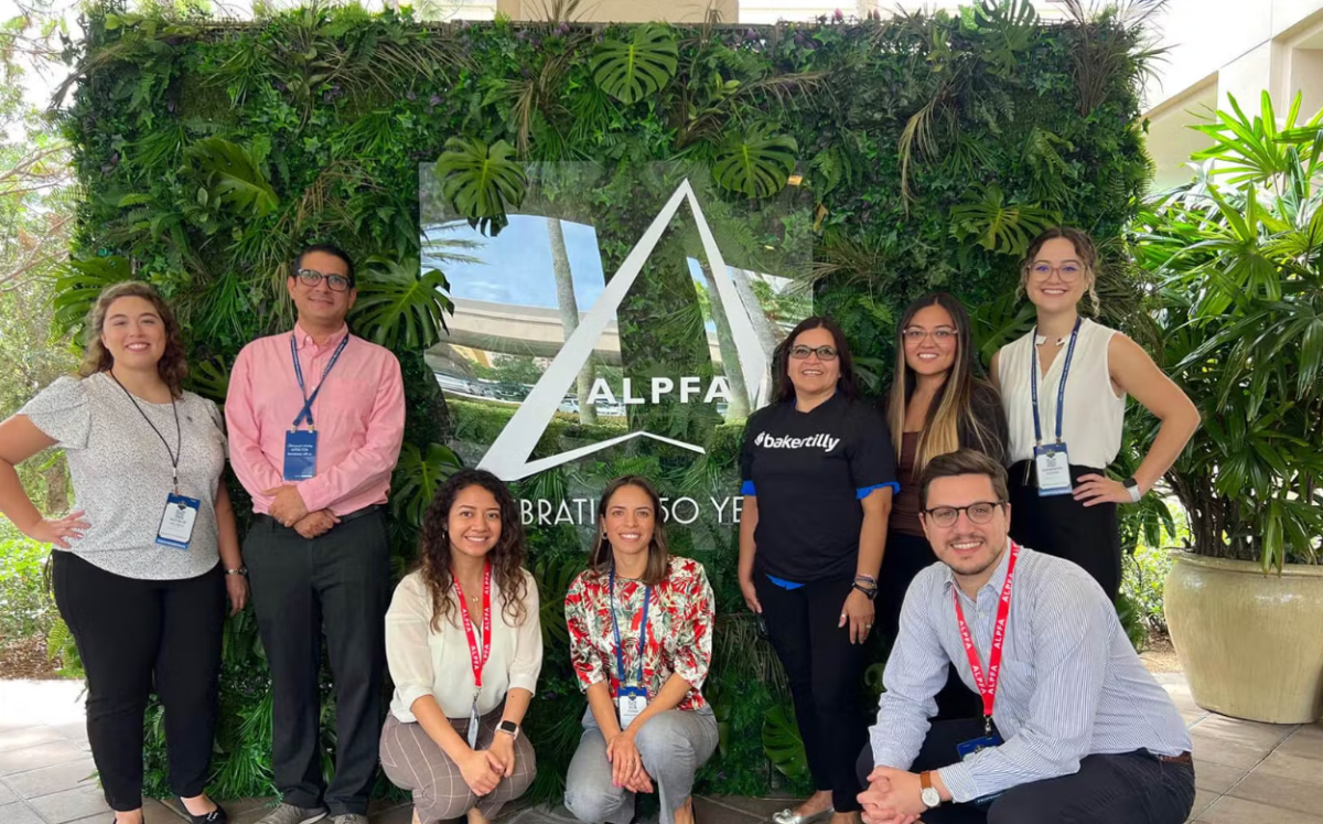 A team posed in front of a ALPFA sign outside.