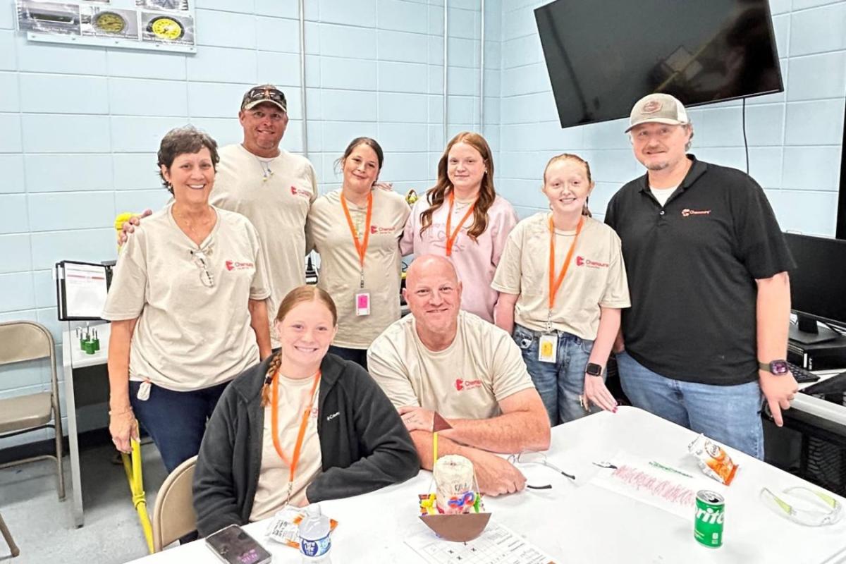A group of 8 people posing in a cafeteria