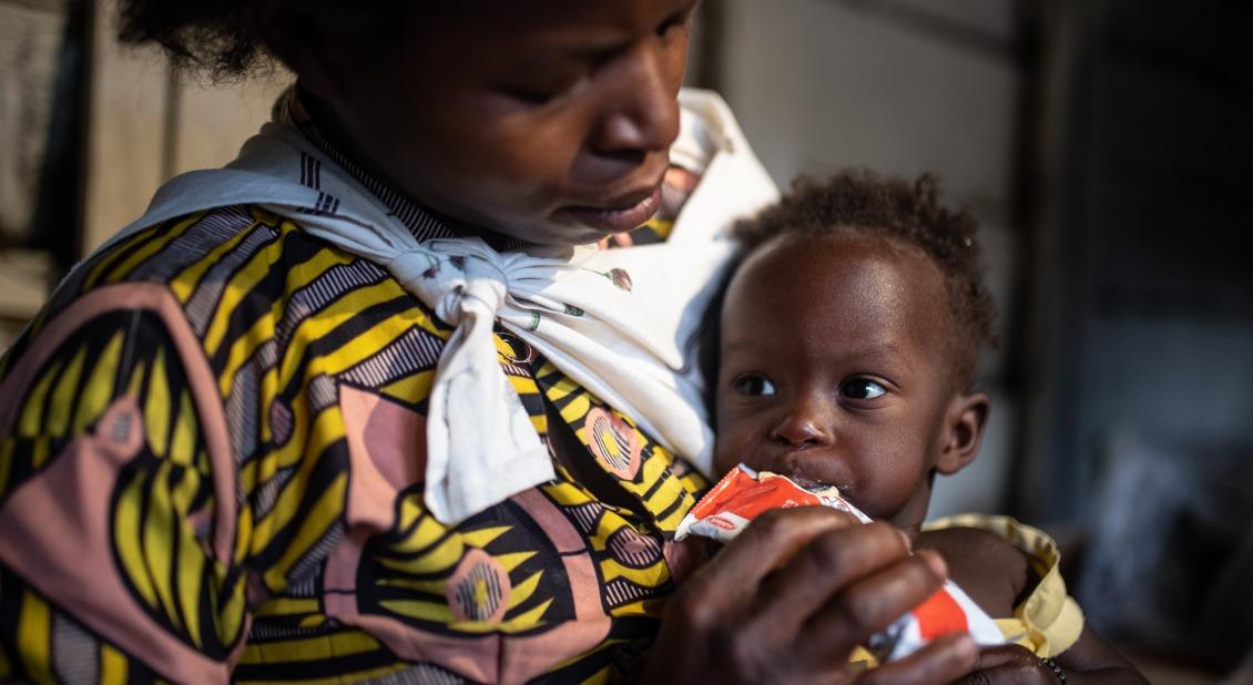 A mother feeds her young child Plumpy'Nut, the peanut butter-like paste used to treat malnutrition.