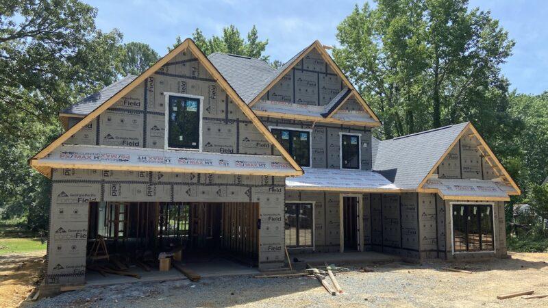 Georgia-Pacific celebrated four years of partnership with the St. Jude Dream Home in Charlotte with a donation of ForceField Weather Barrier System. Image courtesy of LBM Journal. A two-story home being built. Dense trees behind it.