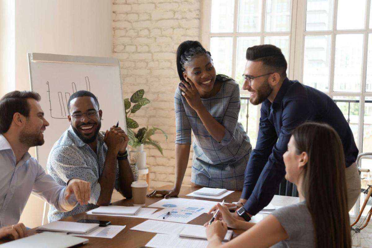 Coworkers talking and laughing at a conference table