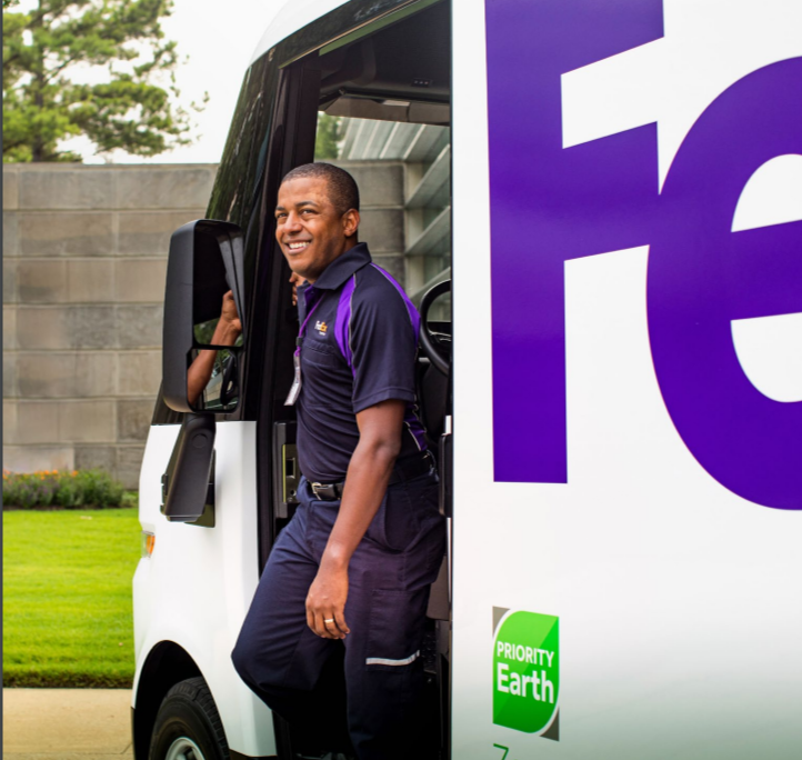 a driver steps out of a FedEx truck