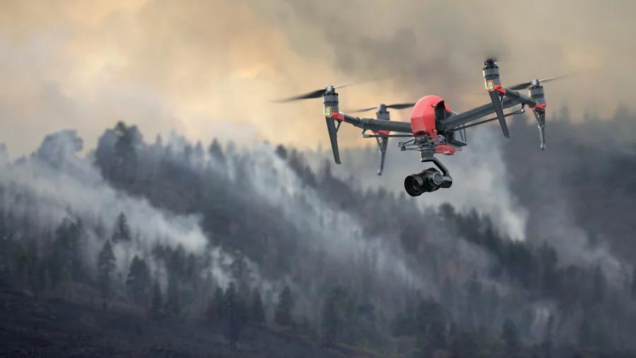 A drone flying over a smoke filled forest.