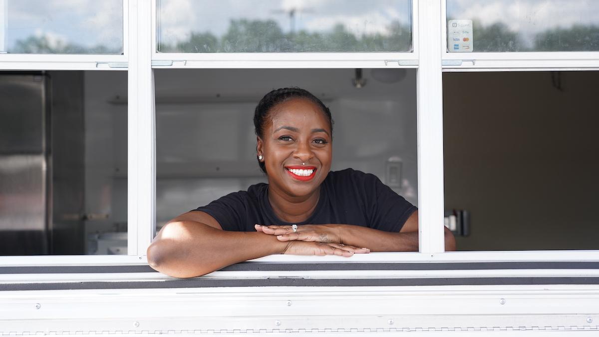 Amber Tellis of Kaylee’s Cake Pops and More leaning out a window