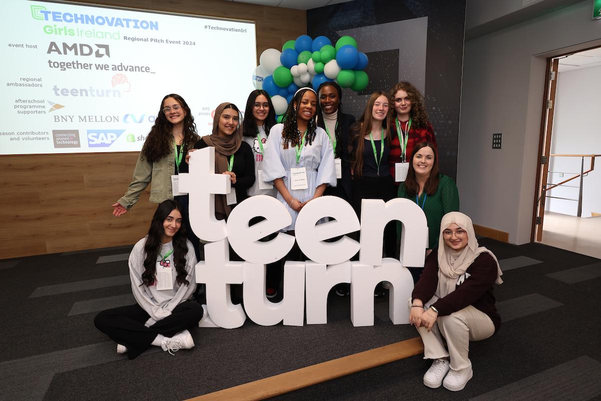 A group posing next to letters that spell "teen turn"
