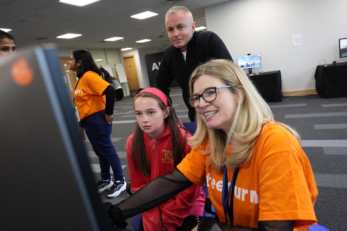 Adults and a child looking at a screen