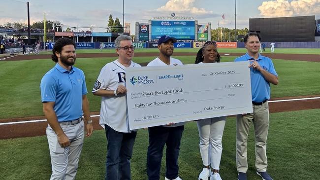 people holding up a large version of a check