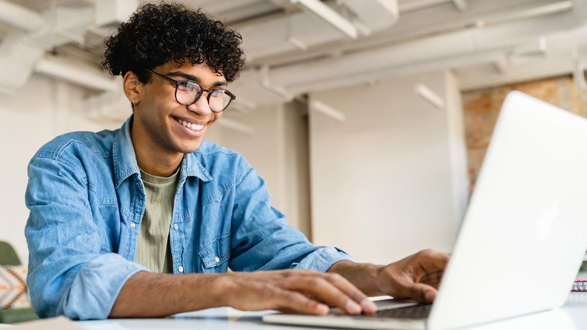 Student shown working in front of a laptop.