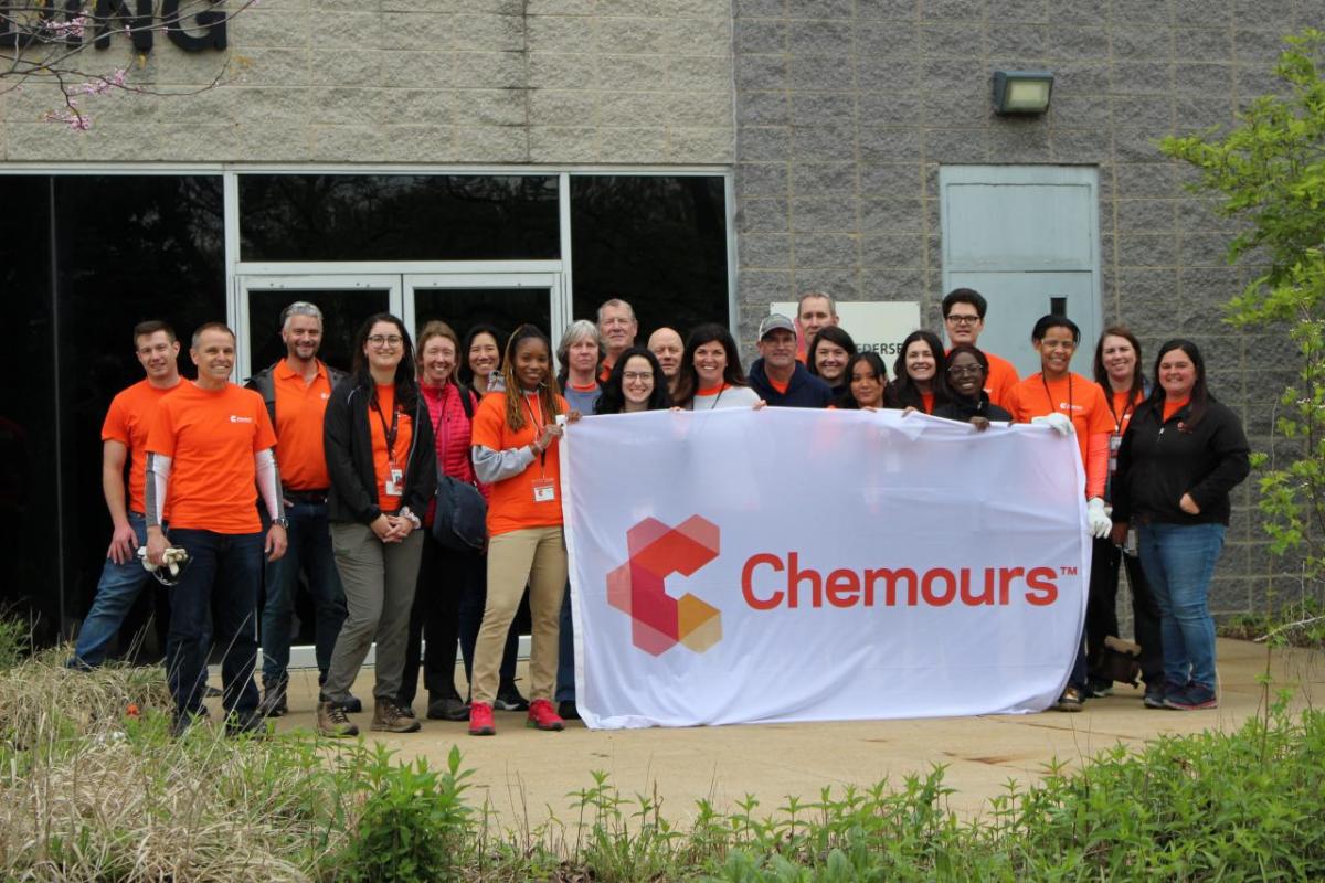 A group of employees posed outside with a "Chemours" banner.