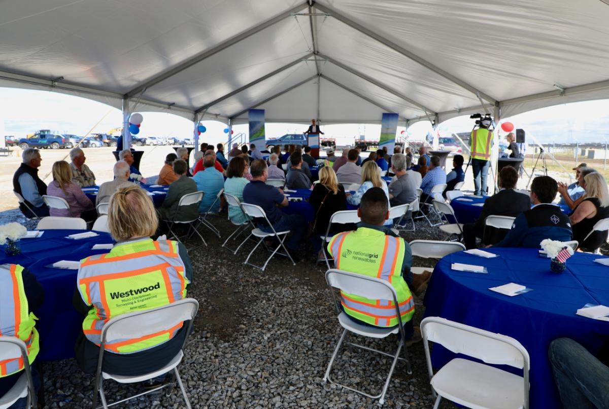 audience sitting under a tent 