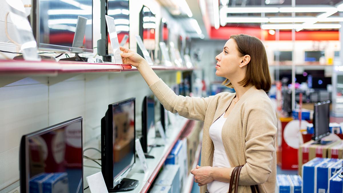 A person is a shop looking at technology products on a shelf