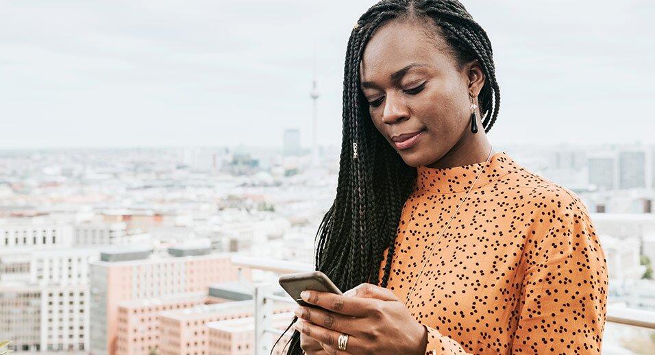 Woman on phone with cityscape behind her
