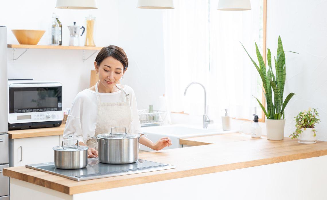 person in white cooking on an electric range