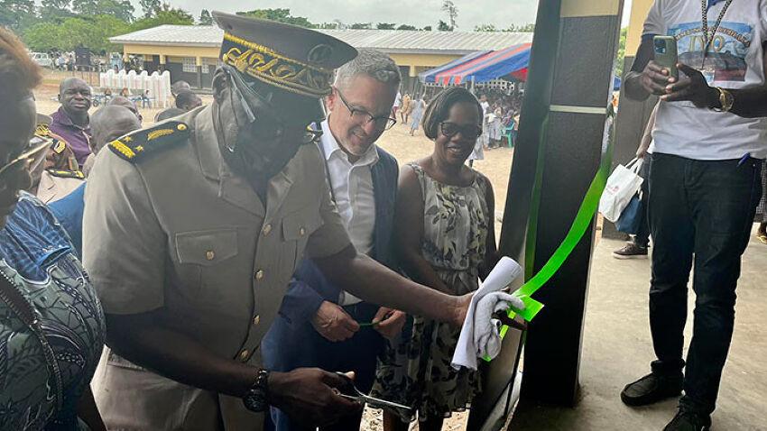 officer cuts the ribbon of a new building with crowd around them