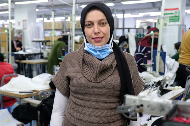 A person standing in a textile factory
