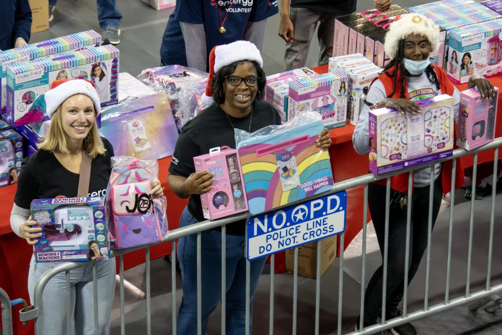 Three people holding up toys