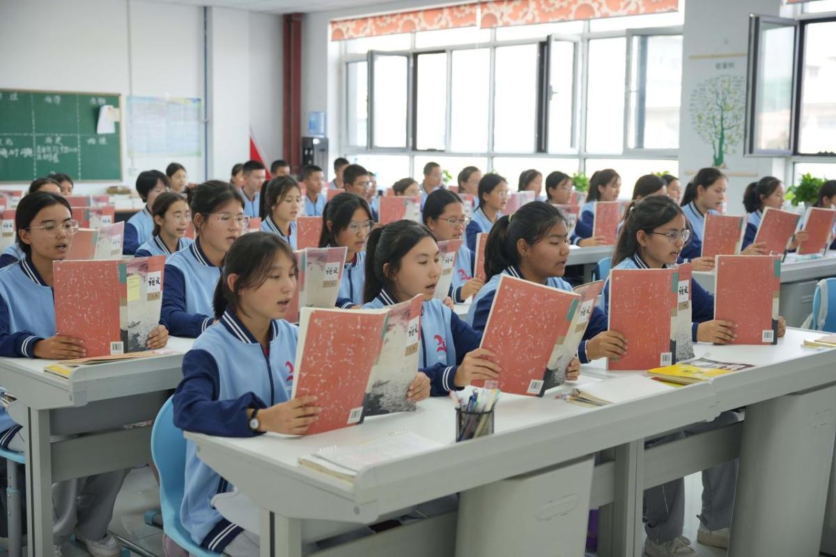 Students sitting in a classroom reading from books