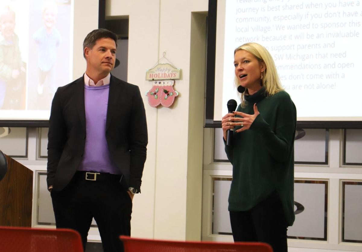 Two people standing behind a podium, one talking.