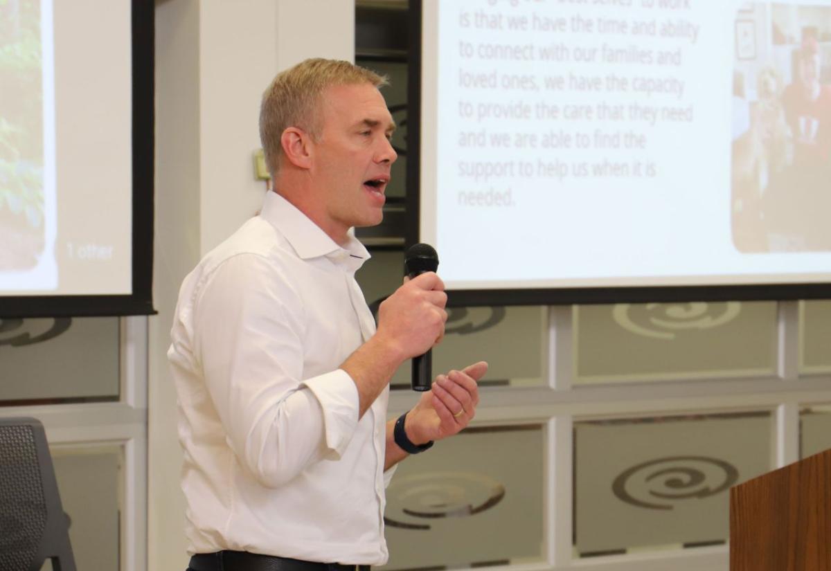 A person with a microphone speaking behind a podium.