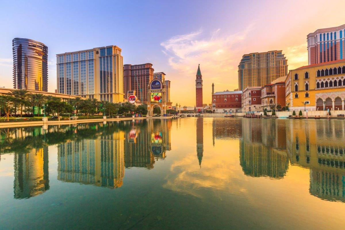 Scenic water view with skyline of tall buildings and sunset in the distance.