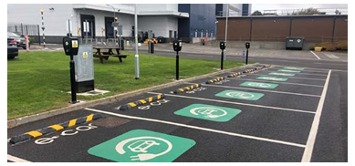 A parking lot with a row of EV charging stations.