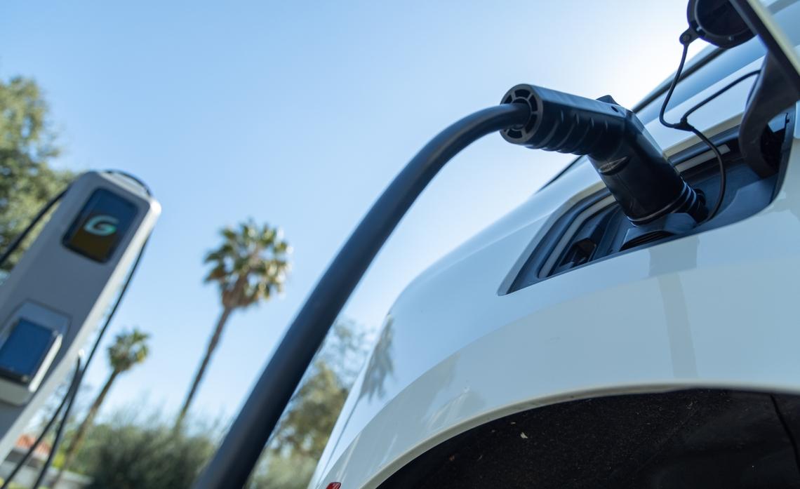 Close up of a vehicle plugged in to an ev charging station.