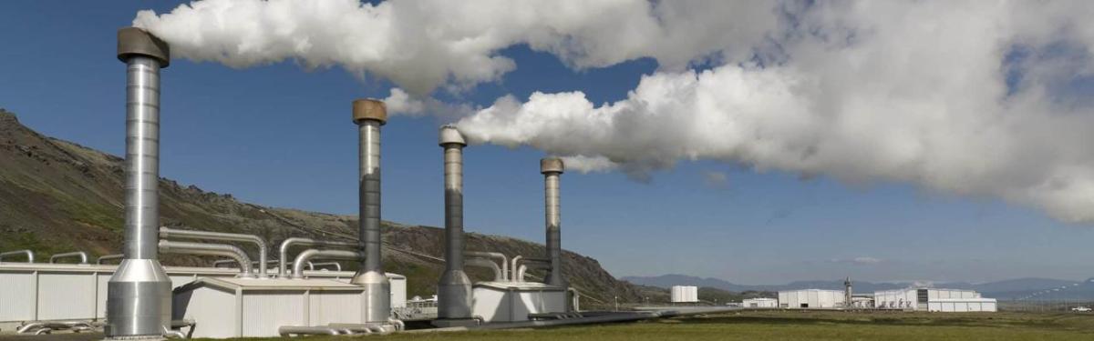 factory with exhaust coming out in front of a blue sky