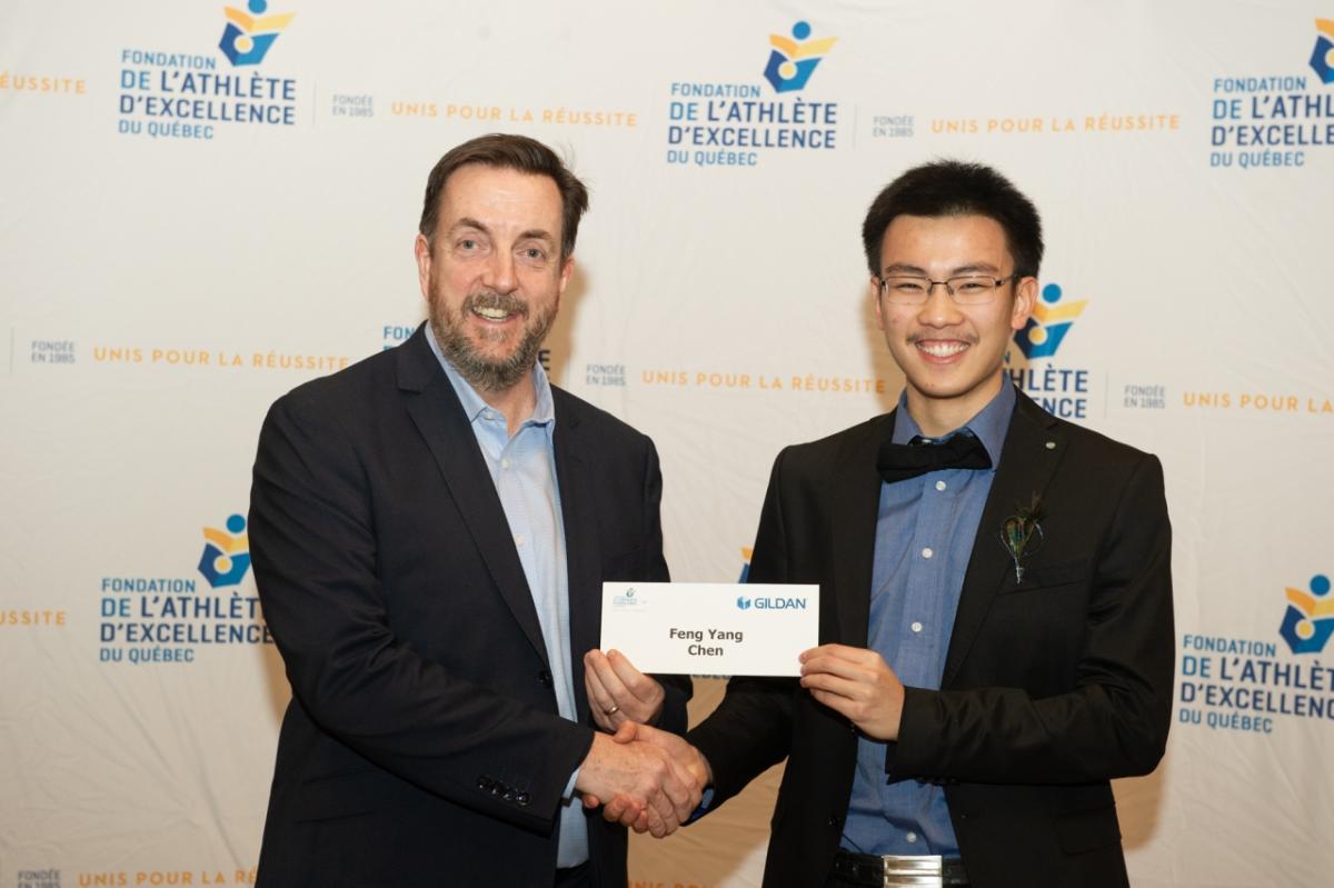 Garry Bell, VP Corporate Communications and Marketing, Gildan presents Feng Chen with a scholarship.