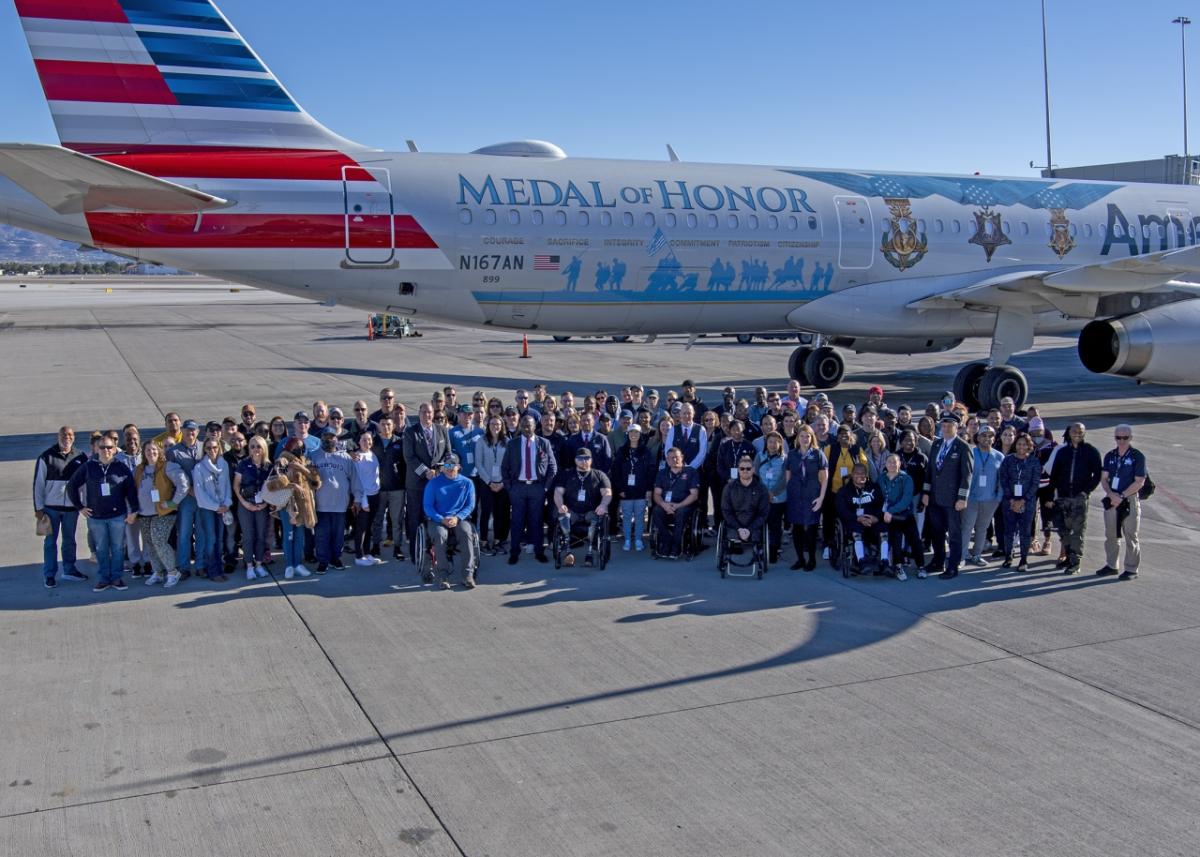 Aerial view of a large group of people in front of the Medal of Honor plane