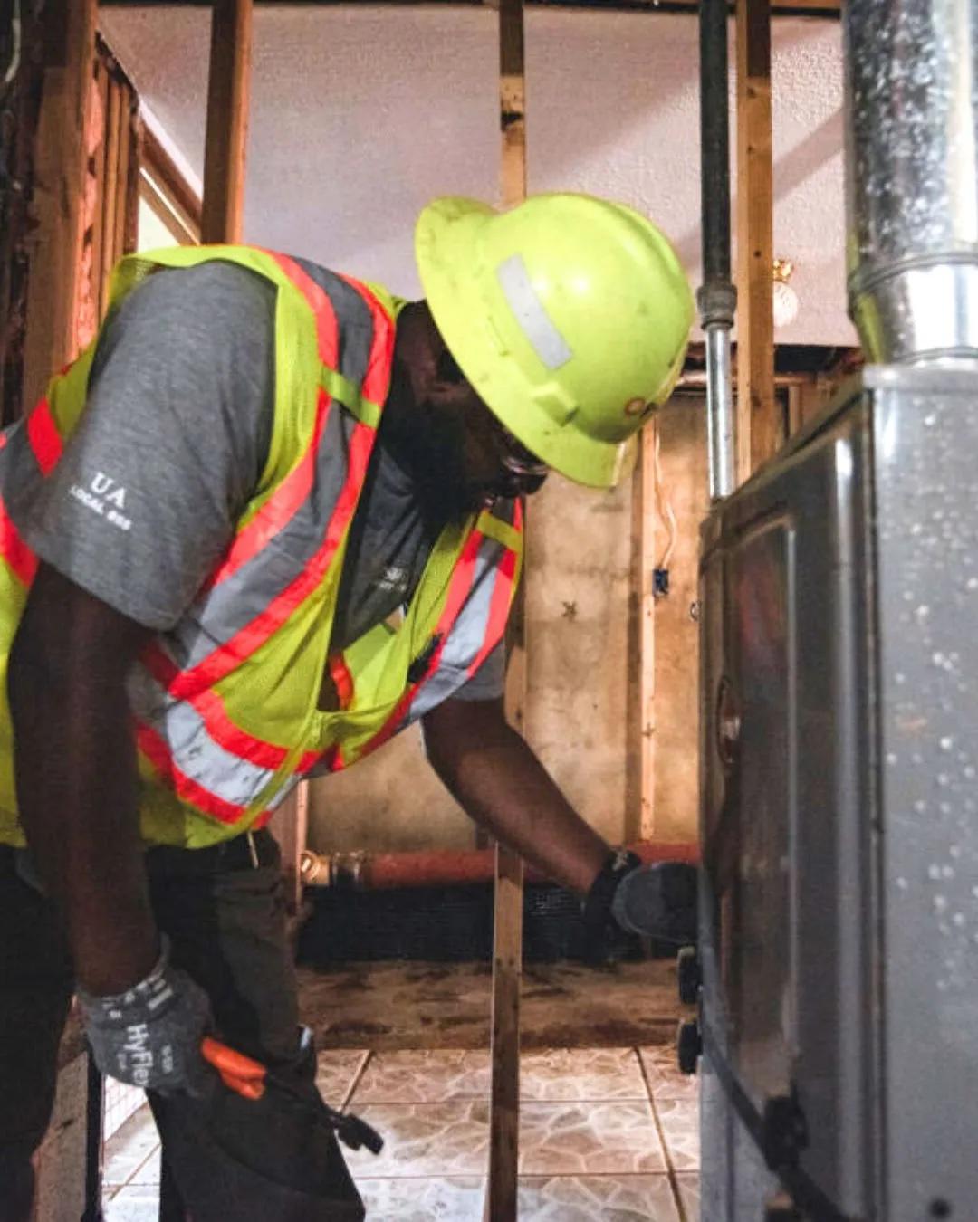 Worker in hard hat looking at fusebox