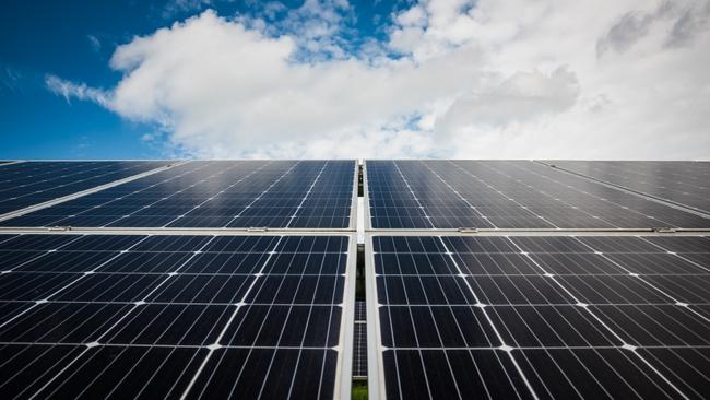 Solar panels against blue sky with clouds