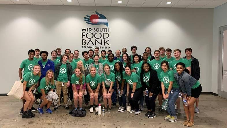 Group of volunteers in front of Mid-South Food Bank sign 