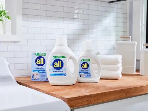 Three bottles of all detergent on a wooden counter.