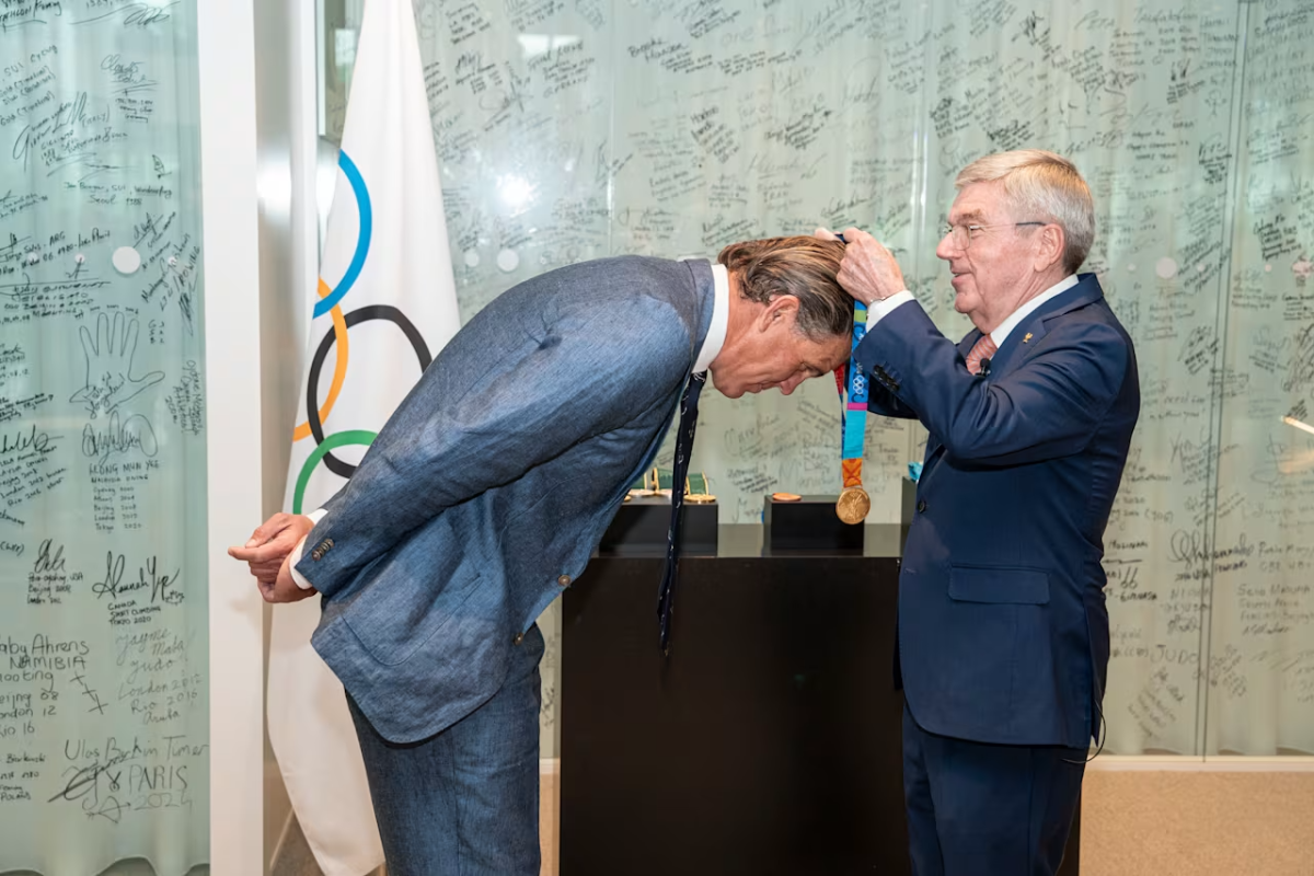 A medal being placed around Gary Hall Jr's neck