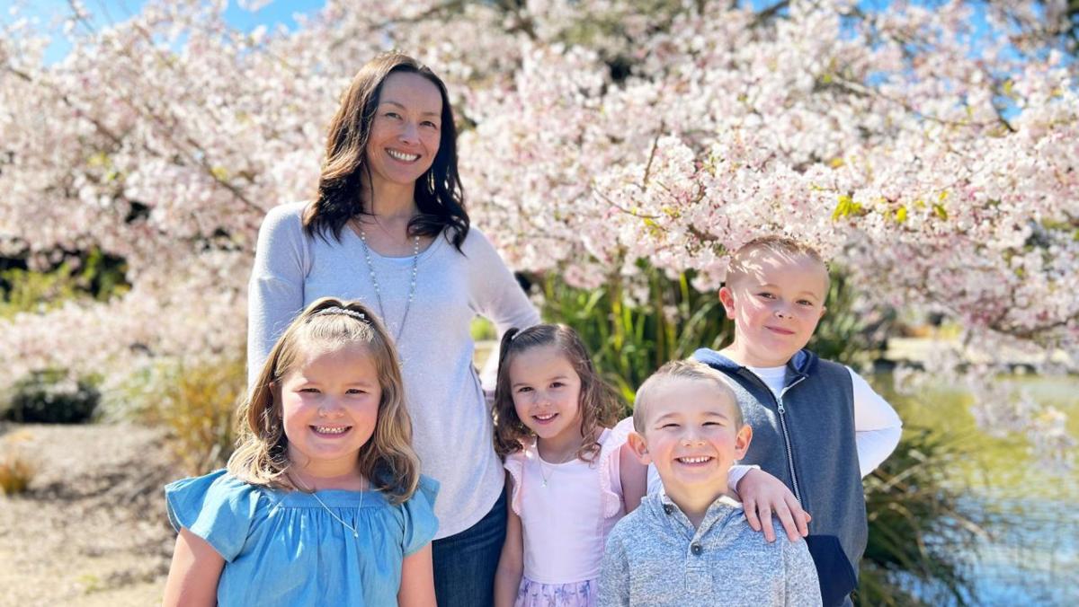 LJ Mizzi and her 4 children standing in front of a flowering tree