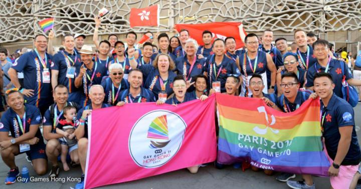 Opening ceremony of Gay Games Paris in 2017. Photo by: Gay Games Hong Kong Large group of people with LBGTQ+ Flag and Gay Games Flag